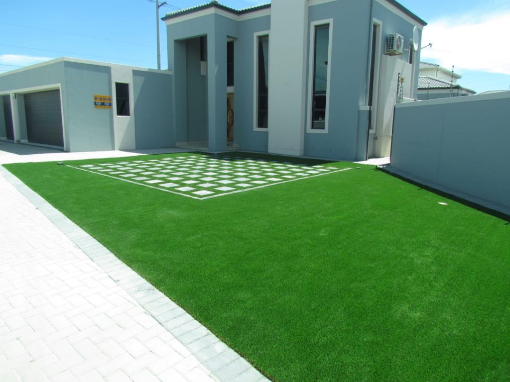 Artifical grass with square cut outs between paving SimpleGrassTurf co za